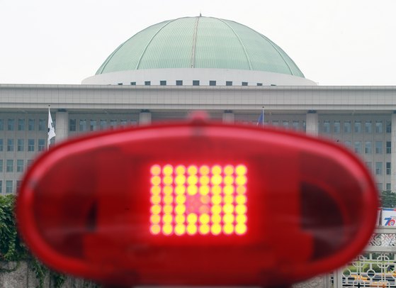 지난 5일 빨간 경광등이 켜진 차량 뒤로 보이는 국회의사당 모습. [뉴스1]