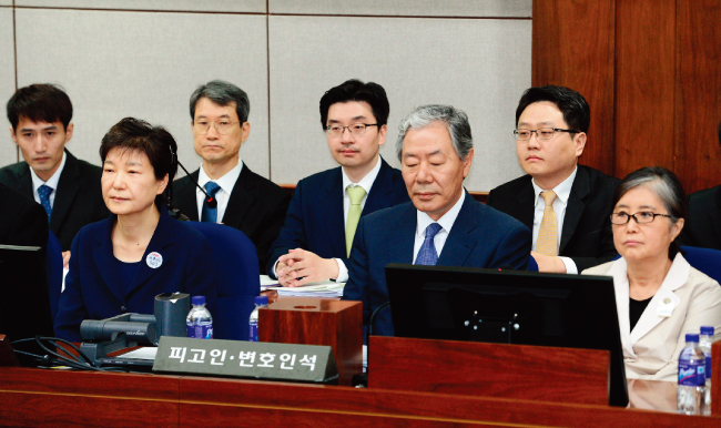 박근혜 전 대통령과 최순실 씨(맨 오른쪽)가 지난해 5월 23일 서울중앙지방법원 417호 대법정 피고인석에 이경재 변호사를 가운데 두고 나란히 앉아 있다. [공동취재단]