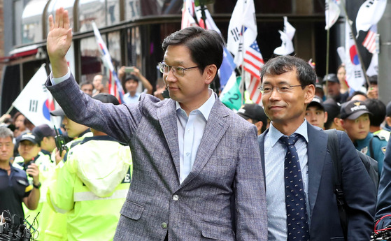 '드루킹' 김동원씨의 댓글조작을 공모한 혐의를 받는 김경수 경남지사가 6일 오전 서울 강남역 인근 허익범 특별검사팀 사무실에 피의자 신분으로 출석했다. 김 지사가 장미꽃을 던지는 지지자들에게 손을 들어 인사하고 있다. 변선구 기자