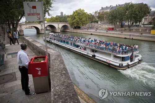 13일(현지시간) 파리 센강 인근에 설치된 공중 소변기 앞에 서 있는 한 남성[AFP=연합뉴스]
