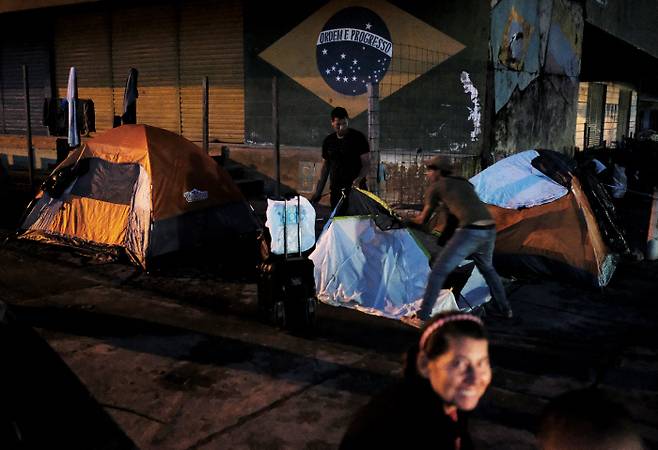 베네수엘라 남성이 지난 8일 브라질 로라이마주 파카라이마시의 한 길거리에서 숙소로 쓸 텐트를 치고 있다. 파카라이마|로이터연합뉴스