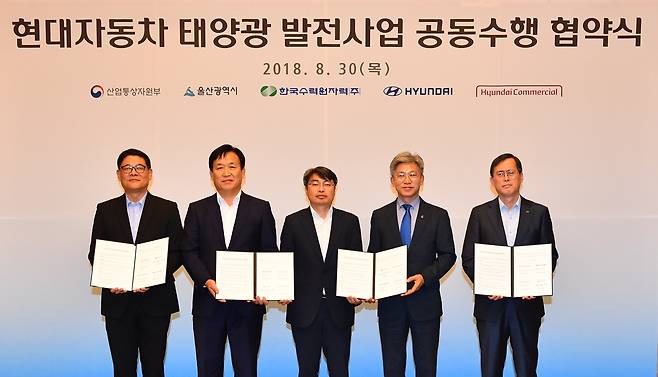김병희 현대커머셜 부사장, 하언태 현대자동차 부사장, 김현철 산업통상자원부 신재생에너지정책단 국장, 송병기 울산시 경제부시장, 정재훈 한국수력원자력 사장이 기념촬영을 하고 있다(현대자동차 제공)© News1