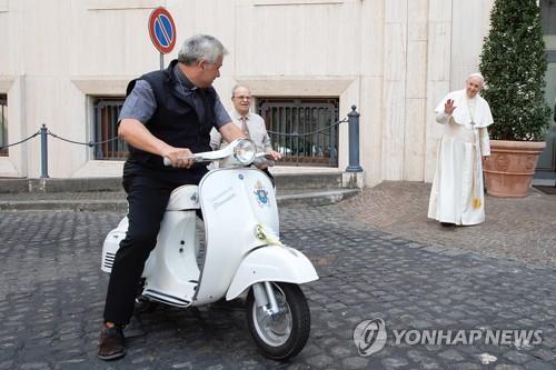 프란치스코 교황(오른쪽)이 2일 선물로 받은 베스파 스쿠터 시운전을 지켜보고 있다. [AFP=연합뉴스]