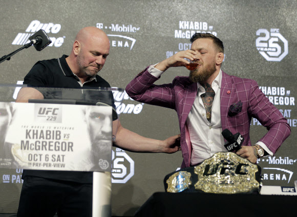 데이나 화이트(왼쪽) UFC 대표가 지켜보는 가운데 코너 맥그리거가 자신의 위스키 제품을 시원하게 들이키고 있다.뉴욕 AP 연합뉴스