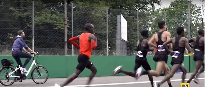 2017년 5월 나이키가 이탈리아 밀라노 근처의 몬차 포뮬러원 경기장에서 연 ‘브레이킹 2’ 행사에서 엘리우드 킵초게 선수(빨간색 옷)가 코스를 달리고 있다. 나이키 누리집 영상 갈무리