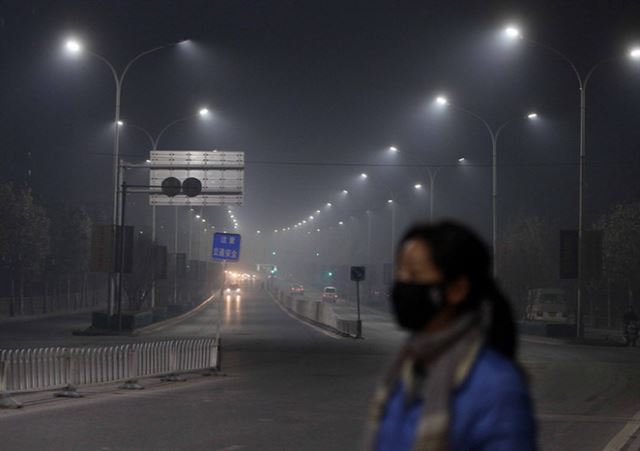 지난 14일 밤 마스크를 쓴 한 시민이 베이징 시내 도로를 지나고 있다. 베이징만보