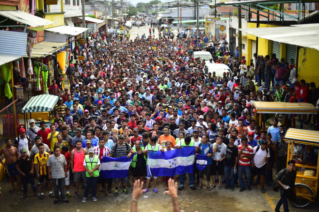 멕시코에 입국하려는 온두라스 출신 이민자들이 20일(현지시간) 국경지대에서 대규모 시위를 벌이고 있다.  AFP=연합뉴스