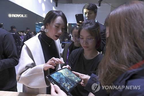 세계 최초 폴더블 스마트폰 살펴보는 예비 고객들 (베이징 AP=연합뉴스) 지난달 31일(현지시간) 중국 베이징에서 열린 디스플레이 전문업체 로욜레의 제품공개 행사장에서 방문자들이 세계 최초 폴더블 스마트폰 '플렉스파이'(FlexPai)를 살펴보고 있다. (끝)
