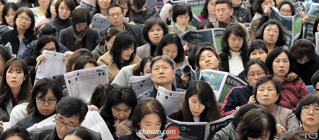 수능 국어 쇼크… 이젠 엄마·아빠들의 대입 전쟁 - 수능 다음 날인 16일 서울 이화여대 대강당에서 열린 한 입시업체 대입 설명회에서 학부모들이 심각한 표정으로 자료를 보며 강사 설명에 집중하고 있다. 이날 설명회엔 전체 좌석 3000석의 두 배가 넘는 6500여 명이 참석했다고 주최 측은 밝혔다. 올 수능에서 어렵게 출제된‘국어 쇼크’로 수험생의 성적이 대폭 떨어졌다. /장련성 객원기자