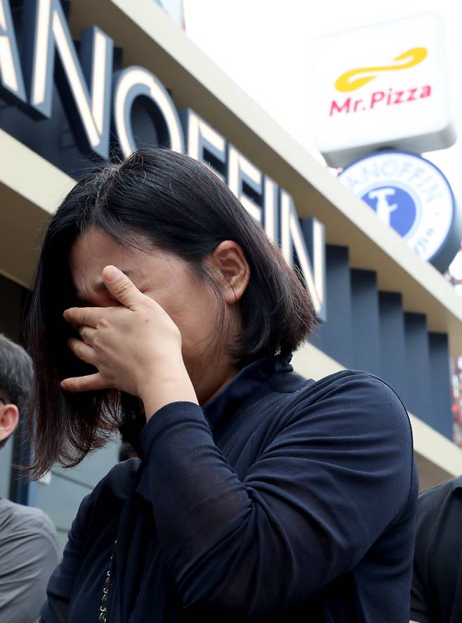 2017년 미스터피자 가맹점주협의회 한 회원이 MP그룹 앞에서 기자회견 도중 눈물을 닦고 있다. / 연합뉴스