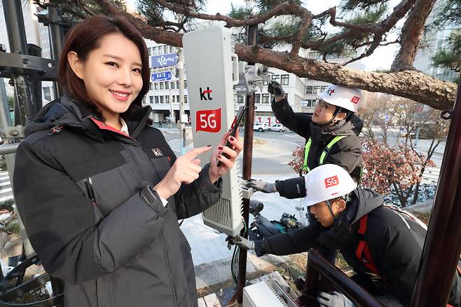 KT 직원들이 광화문에 설치된 5G 기지국을 점검하며, 삼성 5G 스마트폰 시제품을 테스트 하고 있다.
