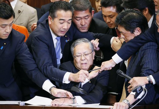 지난 8일 참의원 법무위원회에서 '출입국관리법' 개정안에 반대하는 야당의원들이 요코하마 신이치 법무위원장의 마이크를 뺏으며 의사진행을 방해하고 있다. [AP=연합뉴스]