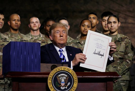 지난 8월 국방 수권 법안에 서명한 뒤 군인들 앞에서 들어보이고 있는 도널드 트럼프 미국 대통령. [로이터=연합뉴스]