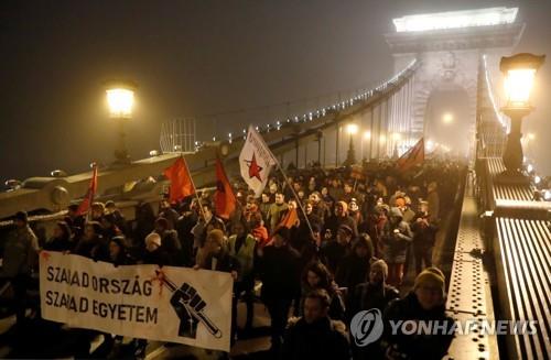 13일(현지시간) 헝가리 부다페스트에서 노동법 개정에 반대하는 시민들이 행진하고 있다. [로이터=연합뉴스]