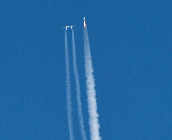 버진 갤러틱의 유인우주선인 스페이스쉽2(오른쪽)가 견인항공기에서 분리돼 솟구치고 있다.유인우주선에는 비행사를 포함해 총8명이 탑승했다.[AFP=연합뉴스]