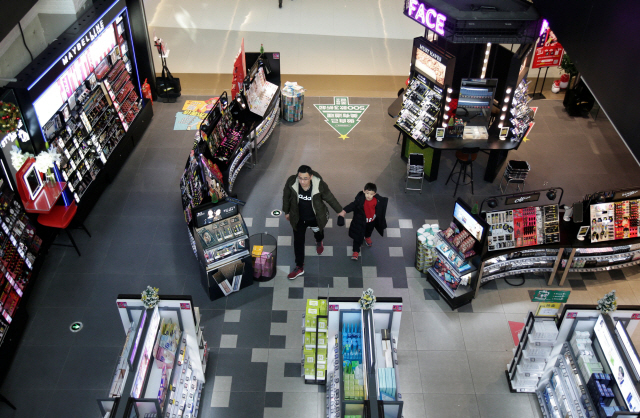 한 남자와 남자 아이가 14일 중국 베이징 쇼핑센터 안을 둘러보고 있다. / (로이터)연합뉴스