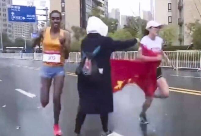 지난달 쑤저우에서 열린 마라톤대회에서 자원봉사자가 1등으로 결승선을 통과하려던 중국 참가자에게 국기를 건네주다 에티오피아 선수에게 1등 자리를 내줘야만 했다. 출처:사우스차이나모닝포스트