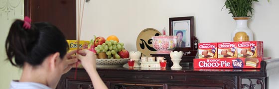 지난달 11일 베트남 호찌민시에 사는 주부 딘 홍 응언씨가 집 안에 마련된 조부의 영정 앞에 초코파이를 올려놓고 제(祭)를 올리고 있다. 응언씨는“20년 전부터 부모님이 제단에 초코파이를 올려왔다”고 말했다. /오리온