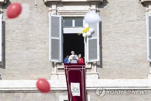 프란치스코 교황이 3일 바티칸에서 열린 일요 삼종기도에서 2명의 어린이와 함께 색깔 풍선을 날리고 있다. [EPA=연합뉴스]