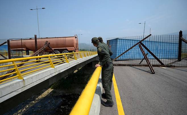 콜럼비아 경찰이 6일(현지시간) 티엔디타스 대교위에서 베네수엘라 군이 설치한 차단시설을 보고 있다. [AFP=연합뉴스]