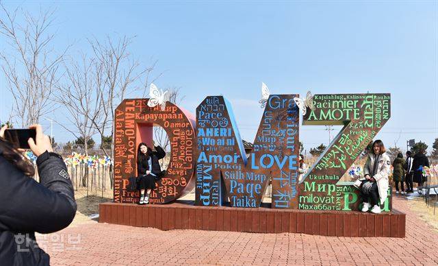 관람객들이 DMZ박물관 야외전시장의 조형물에서 밝은 표정으로 기념 사진을 찍고 있다.