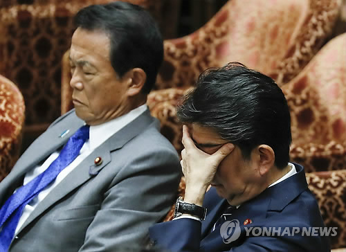 아베 시조 일본 총리(오른쪽)가 중의원 예산위원회에 출석, 고개를 숙인 채 얼굴을 손으로 가리고 있는 모습 [EPA=연합뉴스 자료사진]