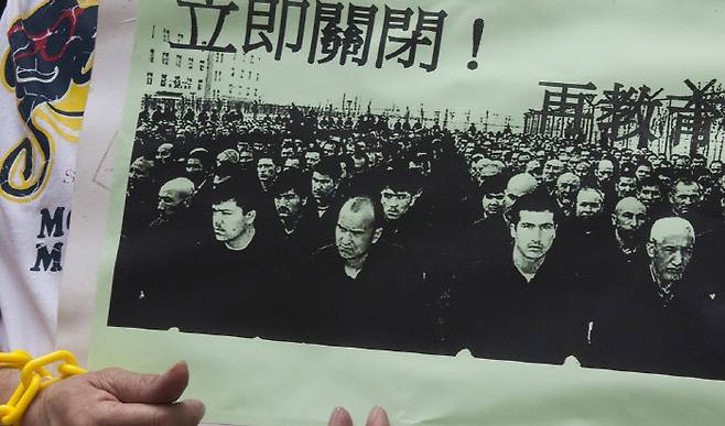 홍콩에서 지난해 9월 열린 중국 당국의 신장지역 위구르족 탄압에 항의하는 시위에서 한 참석자가 ‘수용소 즉각 폐쇄’ 문구가 담긴 사진을 들고 있다. 홍콩 | EPA연합뉴스