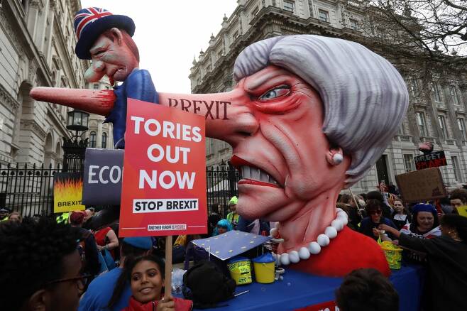23일(현지시간) 영국 런던 중심의 화이트홀거리에서 브렉시트(영국의 유럽연합 탈퇴) 철회를 위한 국민투표 실시를 요구하는 대규모 시위가 진행된 가운데 테리사 메이 영국 총리의 코가 '영국 경제'를 의미하는 인형을 찌르고 있는 모형이 등장했다. /AFPBBNews=뉴스1