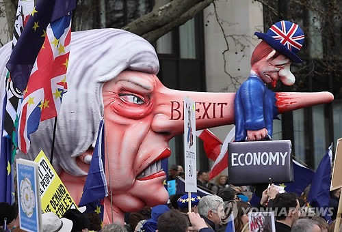 '제2 국민투표 하자!' 브렉시트 반대행진에 등장한 메이 총리 인형 (런던 AFP=연합뉴스) 23일(현지시간) 영국 런던에서 브렉시트(영국의 유럽연합 탈퇴)를 반대하는 대규모 시위가 벌어진 가운데 시위 참가자들이 테리사 메이 영국 총리를 묘사한 인형의 코가 영국 경제를 상징하는 인형을 찌르는 조형물을 들고 행진하고 있다. 주말인 이날 수십만 명의 시민들은 런던에 모여 브렉시트 취소를 위한 '제2 국민투표'를 요구하는 집회를 벌인 뒤 행진했다. leekm@yna.co.kr