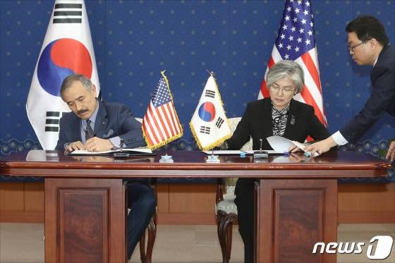 (서울=뉴스1) 신웅수 기자 = 강경화 외교부 장관과 해리 해리스 주한 미국대사가 8일 서울 종로구 외교부 청사에서 열린 한-미 방위비분담금특별협정 서명식에서 협정서에 서명하고 있다. 한미는 지난달 10일 유효기간 1년(2019년)에 총액 1조389억원(작년 대비 8.2% 인상)의 협정안에 가서명했다. 2019.3.8/뉴스1 <저작권자 © 뉴스1코리아, 무단전재 및 재배포 금지> / 사진=(서울=뉴스1) 신웅수 기자