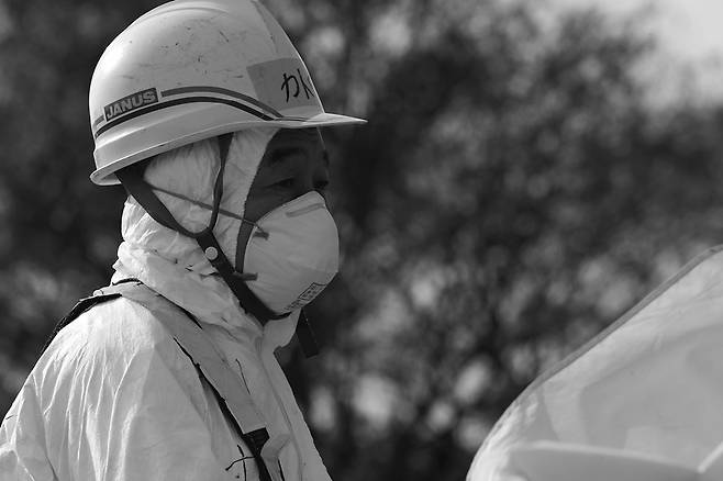 후쿠시마 핵발전 단지 들머리에서 교통 통제를 하는 노동자.