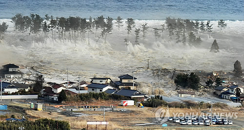 지난 2011년 동일본대지진 당시 지진해일(쓰나미)가 미야기(宮城)현 나토리시 마을을 덮치는 모습 [교도=연합뉴스 자료사진]