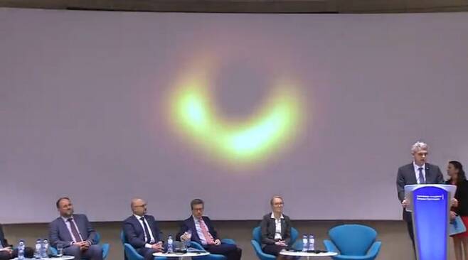 10일 밤 10시(한국시간) 벨기에 브뤼셀에서 개최된 사건지평선망원경(EHT) 기자회견에서 연구자들이 인류가 처음 관측한 블랙홀 영상을 공개하고 있다. 유럽남방천문대 중계화면 캡쳐