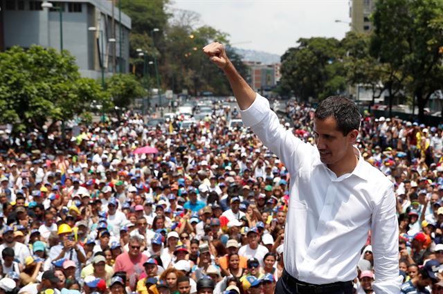 후안 과이도 베네수엘라 국회의장이 1일 카라카스에서 열린 반정부집회에 참석해 한 손은 번쩍 들어올리고 있다. 카라카스=로이터 연합뉴스