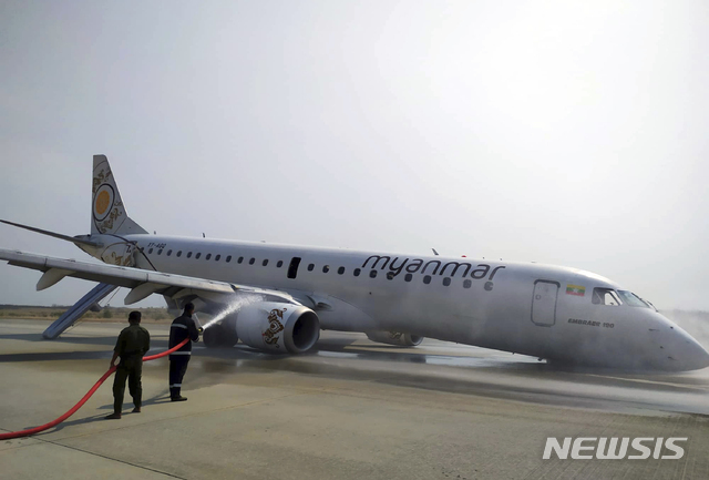 【만달레이=AP/뉴시스】12일(현지시간) 미얀마 만달레이 공항에서 소방관들이 기체 앞부분으로 착륙한 미얀마 항공 여객기에 물을 뿌리고 있다. 이 항공기는 이날 착륙 장치 고장으로 비상착륙했지만 탑승자 82명 전원 무사한 것으로 알려졌다. 2019.05.12