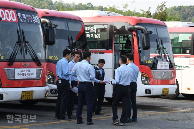 Figure 2 [저작권 한국일보].15일 전국에서 시내버스 파업이 예고된 가운데 14일 경기 용인시 경남여객 차고지에서 기사들이 버스 앞에서 파업관련 대화를 나루고 있다. 배우한 기자