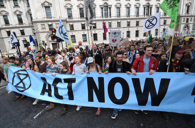 기후변화 대응을 촉구하는 ‘멸종저항’운동 활동가들이 지난 4월 23일(현지시간) 영국 런던의 의회 광장에서 항의시위를 하고 있다. 이들은 영국 정부가 지금 당장 탄소배출 제로사회를 실현하기 위한 행동에 나서야 한다고 촉구했다.  / EPA|연합뉴스