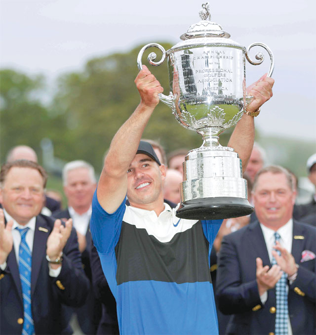 브룩스 켑카(앞)가 20일 미국 뉴욕주 베스페이지 블랙코스에서 열린 제101회 PGA 챔피언십에서 2연패를 달성한 뒤 우승 트로피를 들어 보이며 기뻐하고 있다. 뉴욕=AP 뉴시스