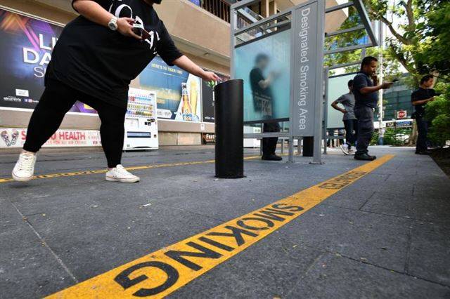 싱가포르 오차드거리에 설치된 흡연구역에서 흡연자들이 담배를 피우고 있다. 스트레이츠타임스 캡처