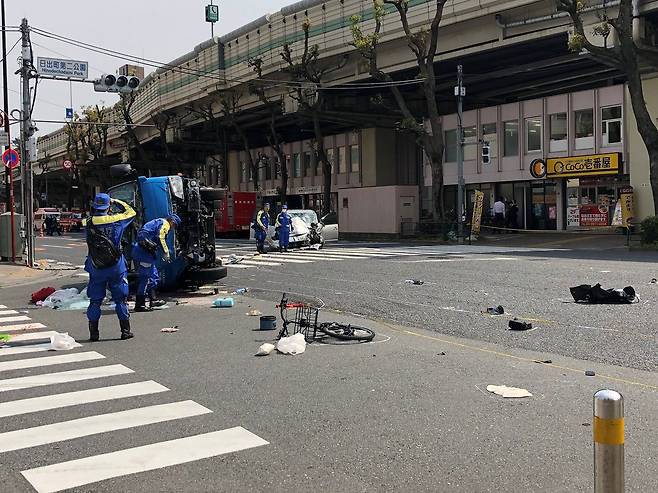 고령자 사고 조사중인 경찰 - 19일 도쿄 히가시 이케부쿠로에서 발생한 87세 승용차 운전자의 연쇄 충돌 사망 사고로 뒤집혀져 있는 차량을 경찰청 교통조사반 관계자들이 살펴보고 있다. 여기저기 쓰러져 있는 피해자들의 소지품과 자전거가 마음을 아프게 한다.                    도쿄 로이터 연합뉴스