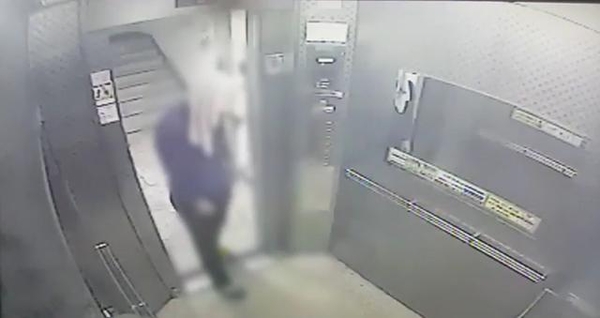 지난달 27일 순천의 한 아파트에서 피의자 A씨가 수건으로 얼굴을 가린 채 엘리베이터에 타고 있다. /연합뉴스