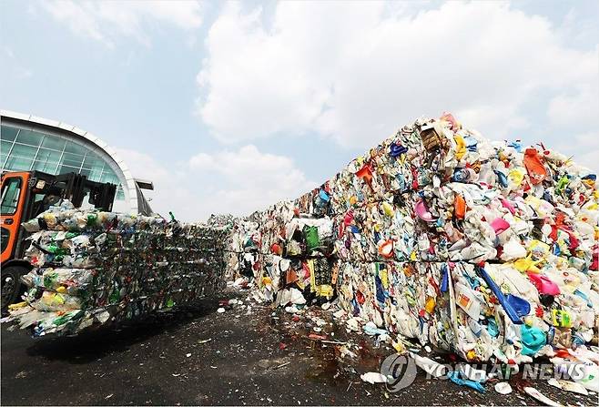 경기도 용인시의 한 재활용센터에서 관계자들이 압축된 플라스틱 등 재활용품을 옮기고 있는 모습. (사진=연합뉴스 제공)