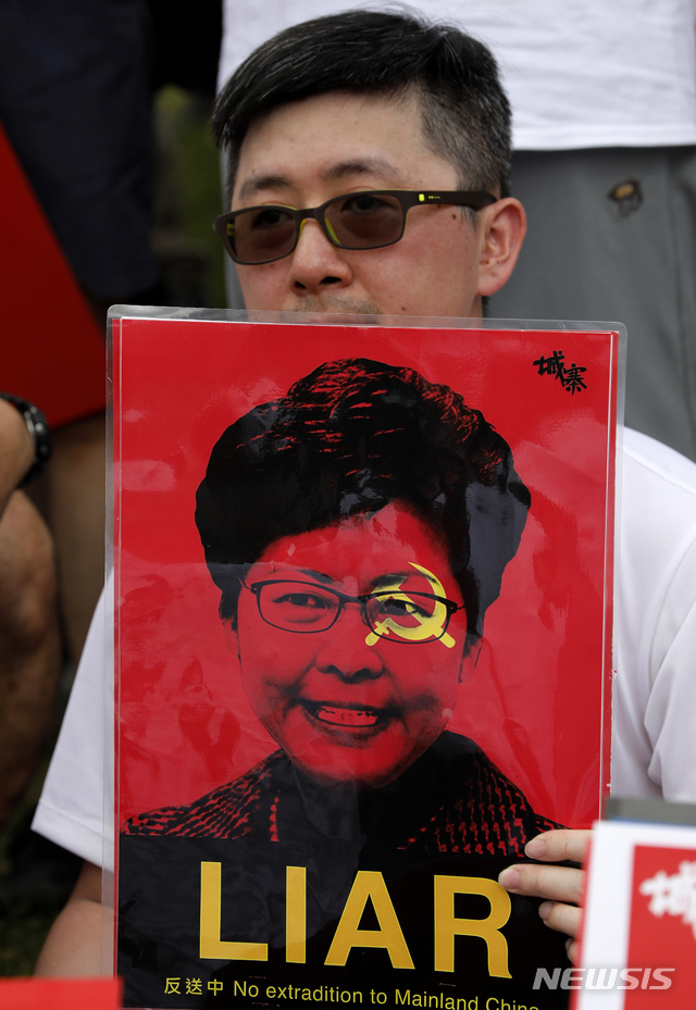 【홍콩=AP/뉴시스】홍콩에서 9일 대규모 '범죄인 인도법' 반대시위가 열린 가운데 한 남성이 캐리 람 행정장관 사진이 '거짓말장이'라고 쓴 종이을 들고 있다. 2019.06.09