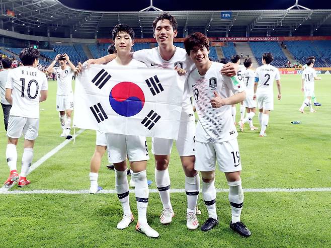 12일 에콰도르를 꺾고 U-20월드컵 사상 첫 결승에 진출한 김현우(왼쪽부터), 오세훈, 최준이 태극기를 들고 기쁨을 나누고 있다. [뉴스1]