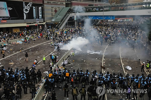 최루탄 발사하며 시위대 해산 시도하는 홍콩 경찰 (홍콩 AFP=연합뉴스) 12일 홍콩 정부청사 건물 주변에서 경찰이 '범죄인 인도 법안'에 반대하는 시위대를 향해 최루탄을 발사하며 해산을 시도하고 있다. leekm@yna.co.kr