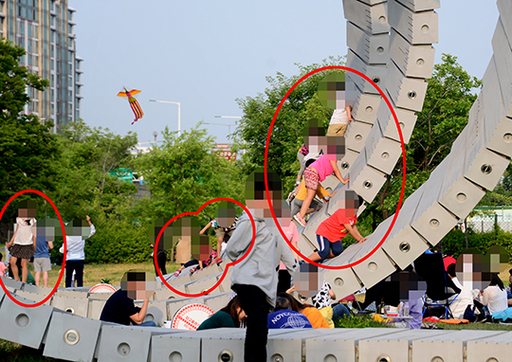 지난 8일 오후 서울 용산구 이촌 한강공원에 설치된 8m 스크룰 예술 작품에 아이들이 뛰어 놀고 있다. 작품 주변에는 ‘타고 올라가지 마세요’라는 경고 표지판이 있지만 지켜지지 않고 있다.