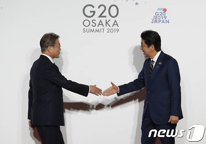 문재인 대통령이 28일 인텍스오사카에서 열린 G20 정상회의 공식환영식에서 의장국인 아베 신조 일본 총리와 악수하고 있다.© AFP=뉴스1 © News1 이동원 기자