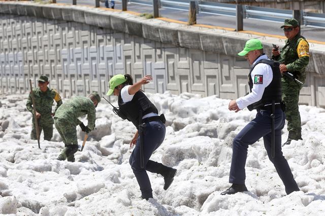 멕시코 과달라하라주 일부 지역에 비와 우박을 동반한 폭풍이 지나간 30일(현지시간) 보안 요원 및 군인들이 눈처럼 쌓인 우박을 치우고 있다.  로이터 연합뉴스