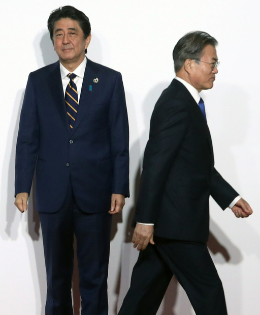 문재인 대통령이 지난달 28일 오전 일본 인텍스 오사카에서 열린 G20 정상회의 공식환영식에서 의장국인 일본 아베 신조 총리와 악수한 뒤 이동하고 있다. 연합뉴스