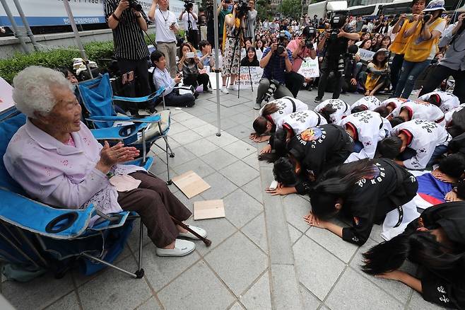 10일 오후 서울 종로구 옛일본대사관터 앞에서 열린 제1395차 일본군 성노예제 문제 해결을 위한 정기 수요시위에서 참가자들이 태권도 퍼포먼스를 마친 뒤 이옥선 할머니에게 큰절을 하고 있다. 백소아 기자